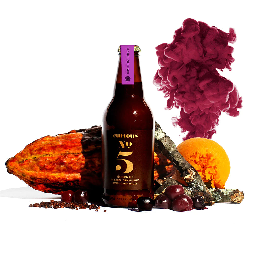 a bottle of curious no 5 surrounded by fruit
