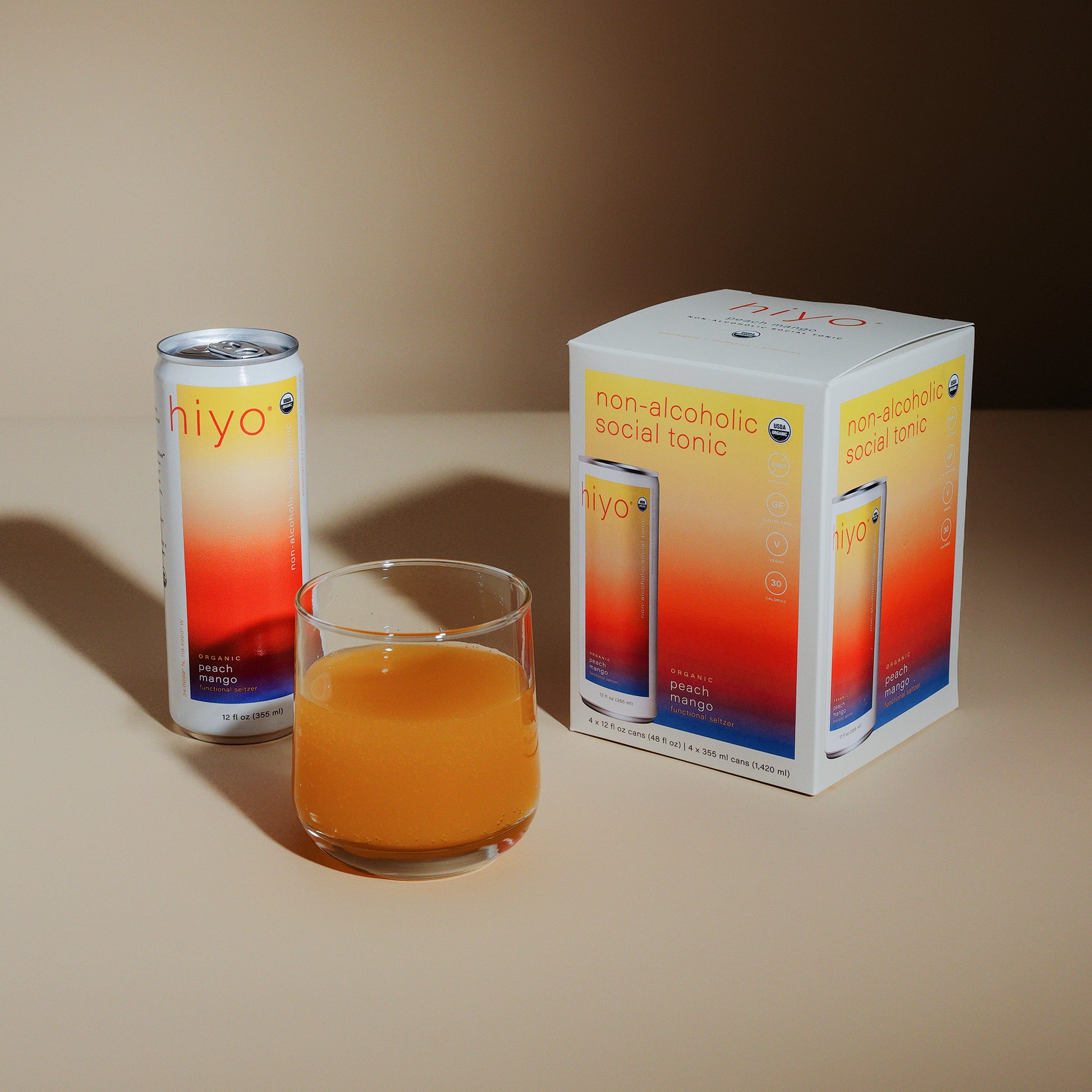 a can, glass and box of peach mango