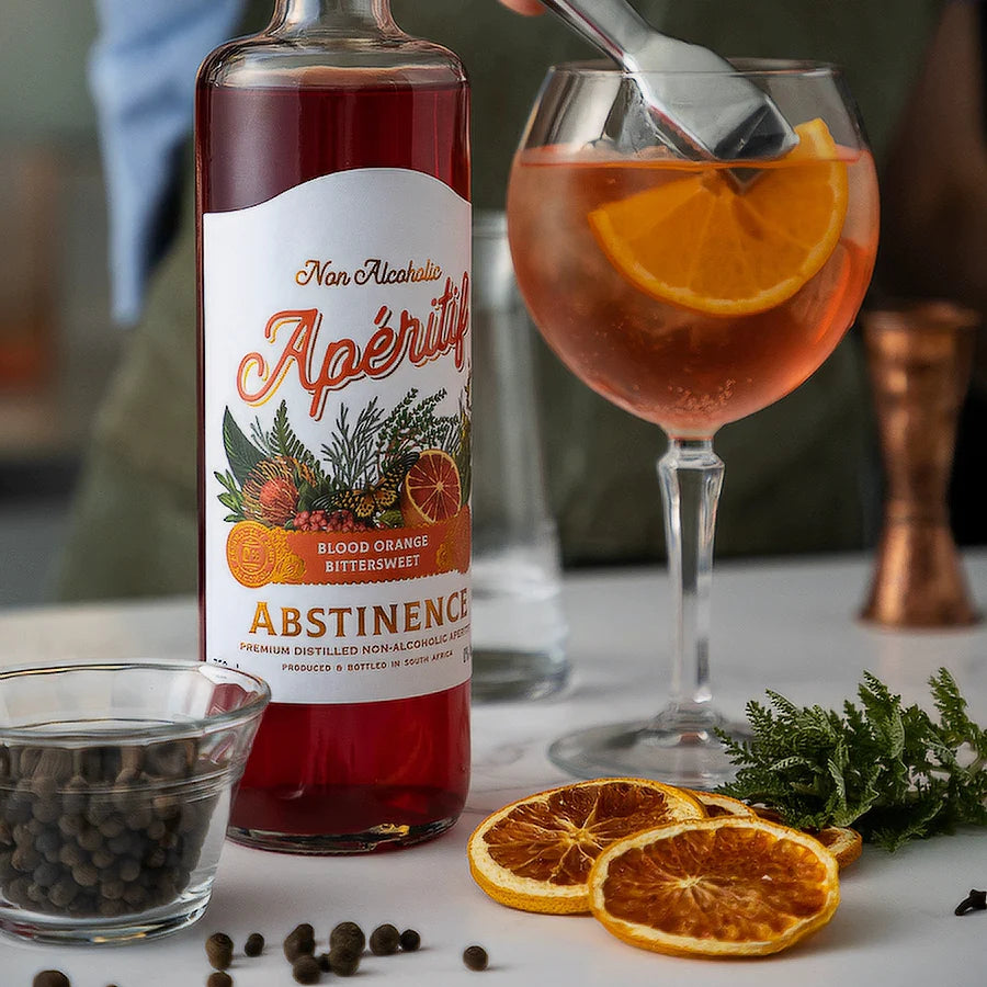 a bottle of blood orange displayed next to a wine glass