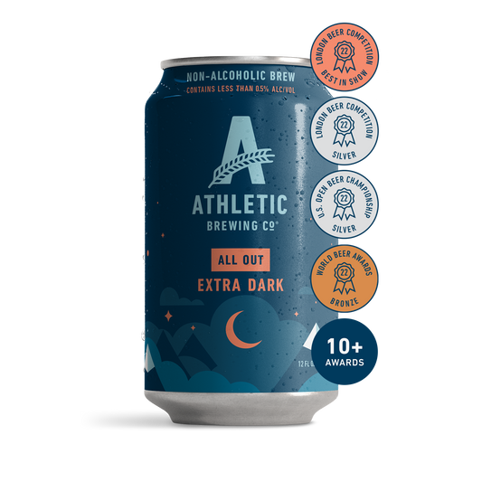 athletic brewing co's all out, extra dark. the can has a simplistic illustration of mountain peaks surrounded by a slightly cloudy night sky