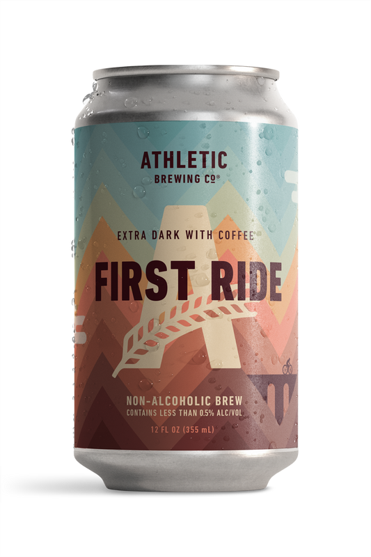 athletic brewing co's first ride, extra dark with coffee. On the can is a simplistic illustration of a figure biking across a bridge surrounded by mountains