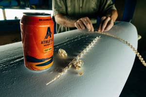 a can of free wave being displayed on a surfboard