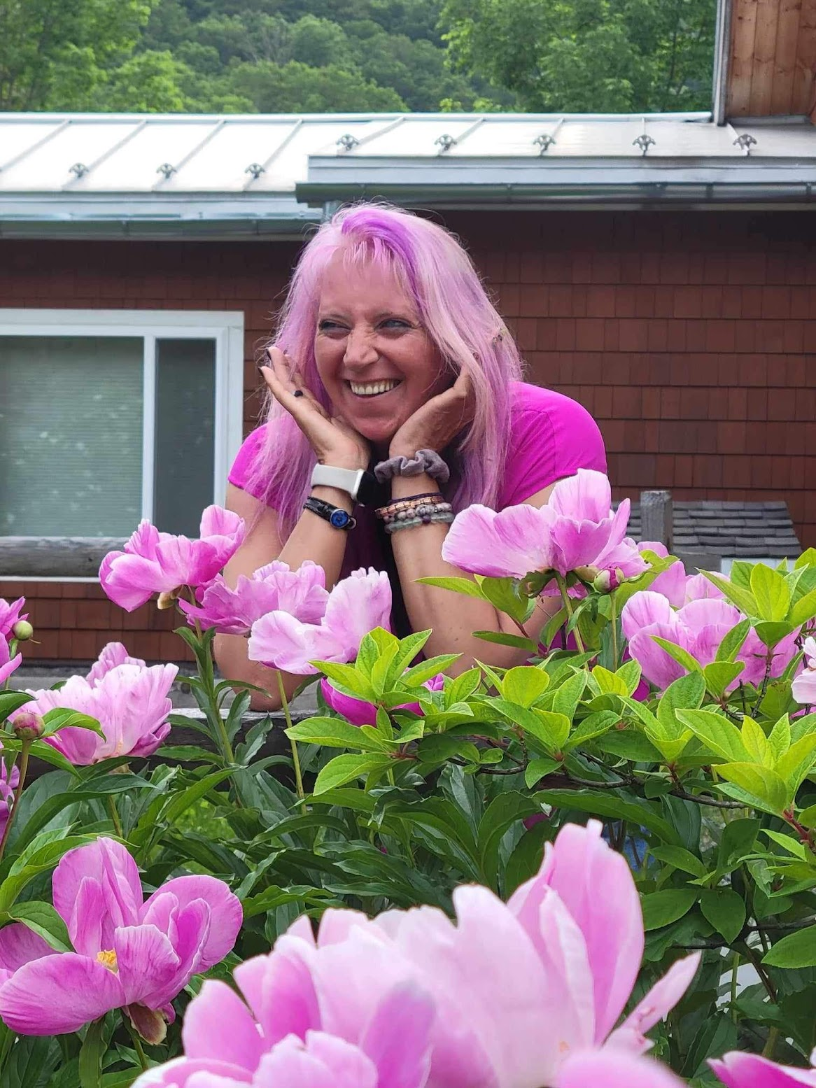 a photo of bobbie posing with some pink flowers