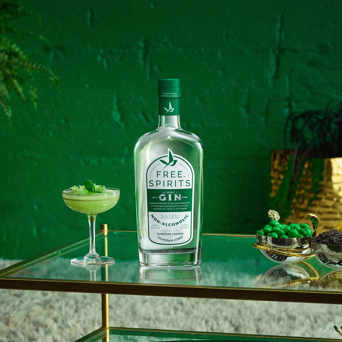 a display of free spirits gin on a glass table next to a green margarita