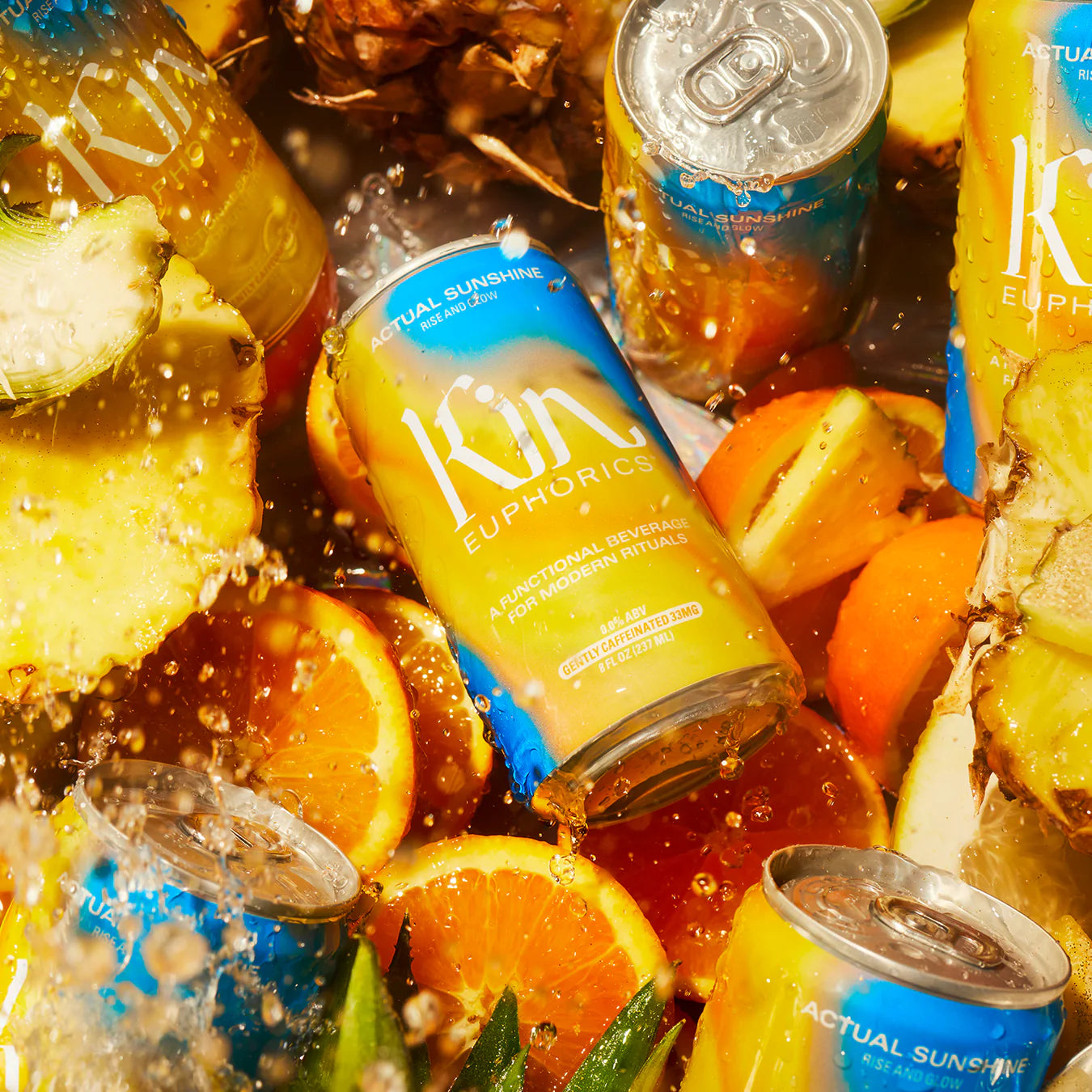 cans of get your glow being splashed in water with orange and pineapple slices