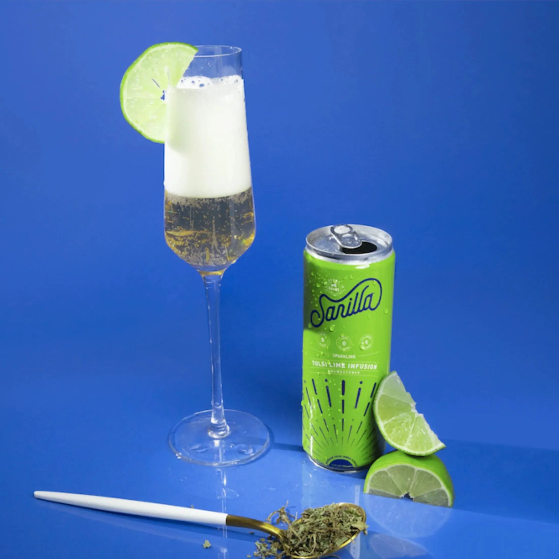 a can of tulsi next to a full glass and lime slices