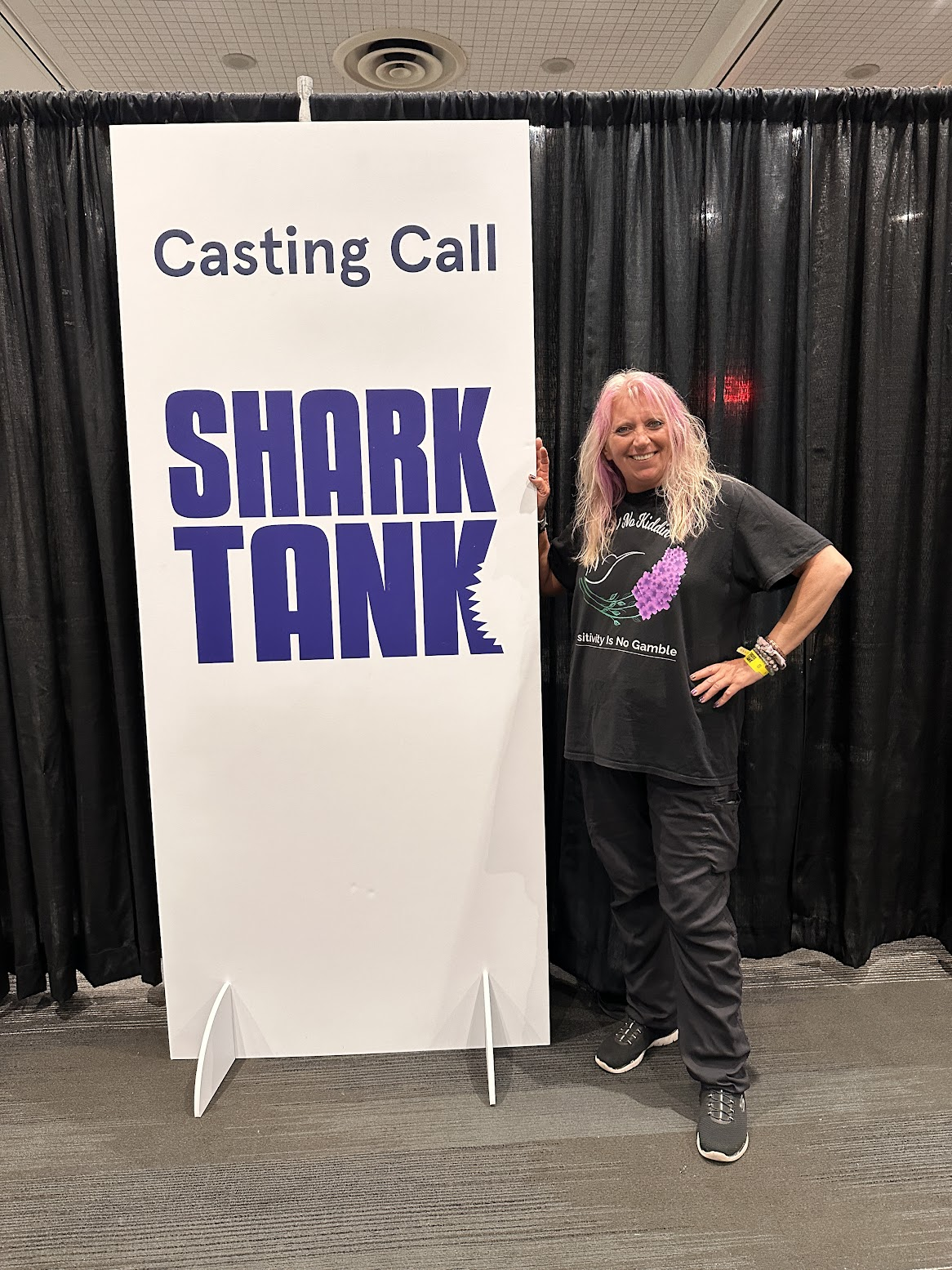 bobbie posing next to the shark tank casting call sign